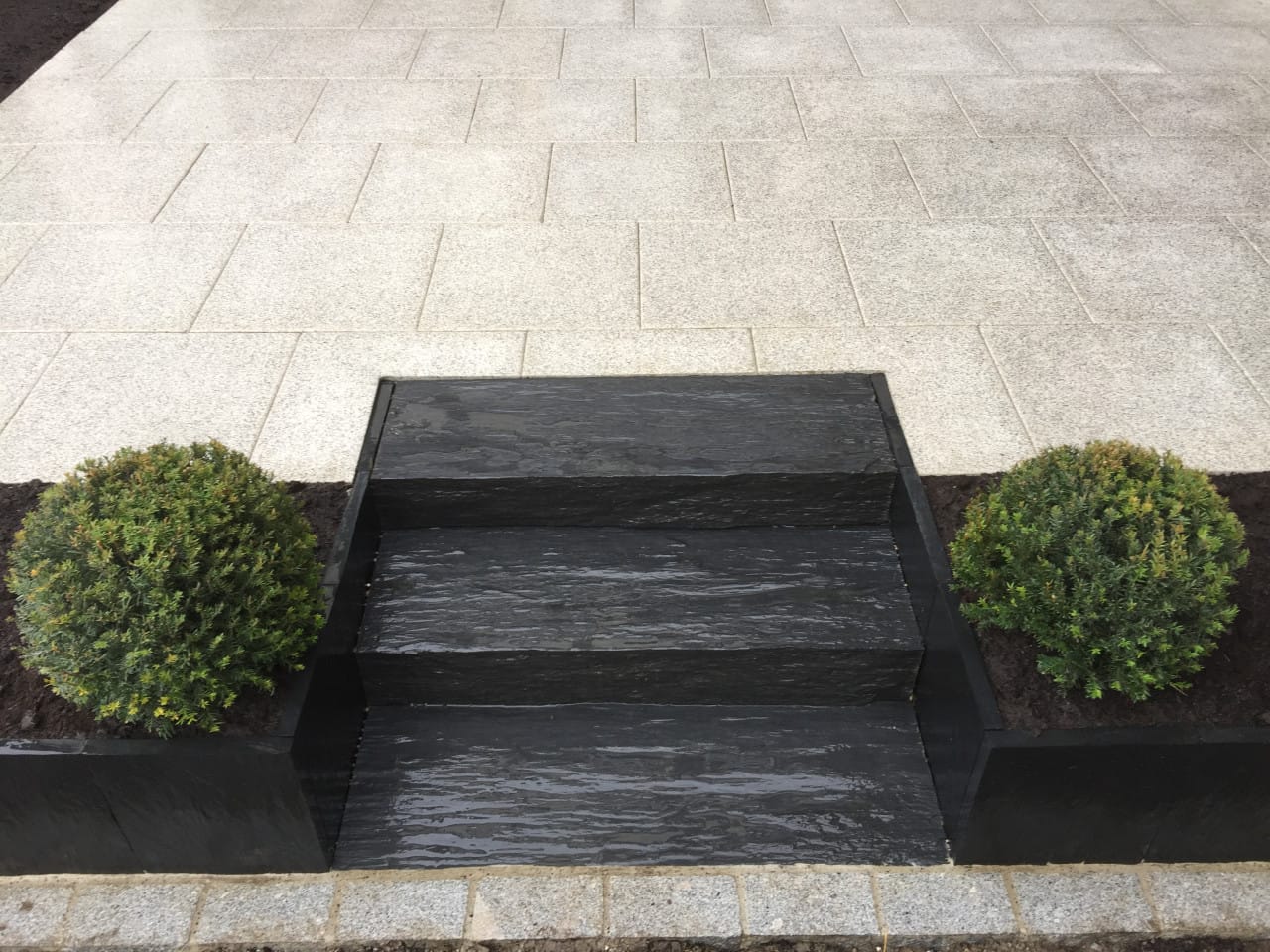Schiefertreppe mit Plattenbelag und Buchskugeln